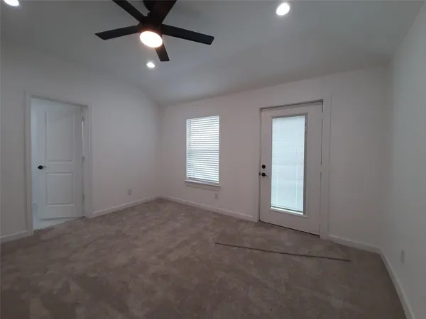 an empty room with ceiling fan and window