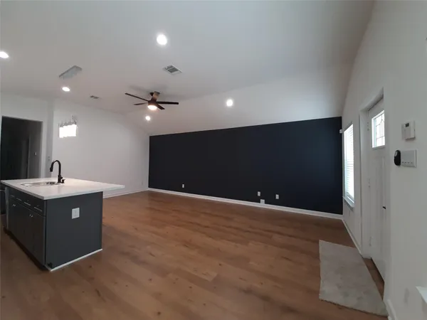 a view of an empty room with wooden floor and a cabinet
