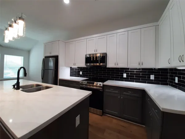 a kitchen with a sink and white cabinets