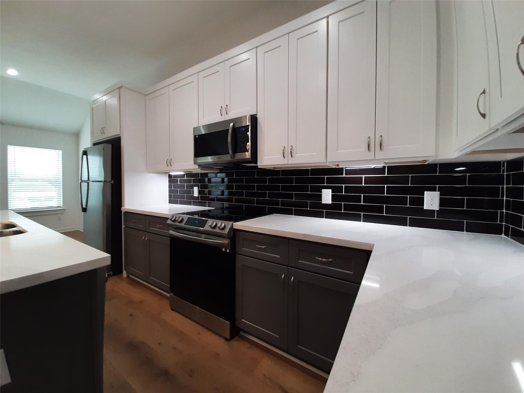 4530 Mayflower Street Houston, TX 77051 - Photo 7 of 21 a kitchen with stainless steel appliances a stove a sink a microwave and cabinets