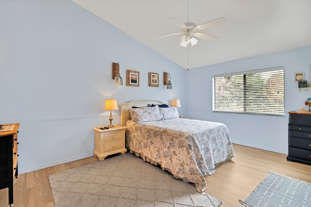 9637 Riverside Drive, Unit 3 Sebastian, FL 32958 - Photo 13 of 36 a bedroom with a bed and a chandelier
