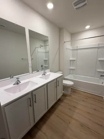 a bathroom with a double vanity sink toilet and shower