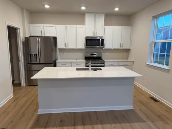 a kitchen with kitchen island a sink appliances and cabinets