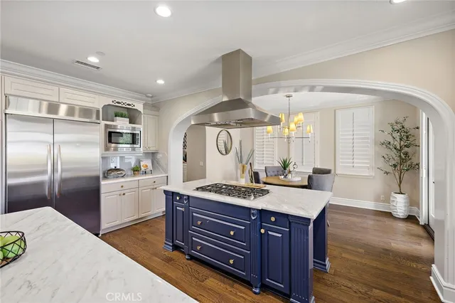 a kitchen with a stove a refrigerator and a wooden floors