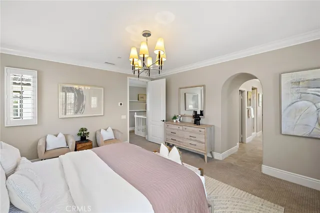 a bedroom with a bed and a chandelier