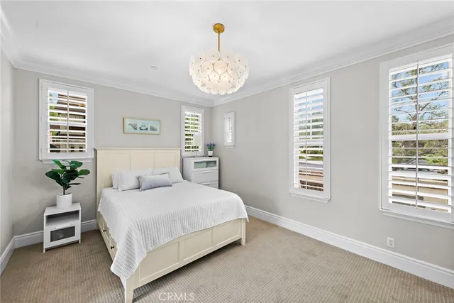 a bedroom with a large bed and a chandelier