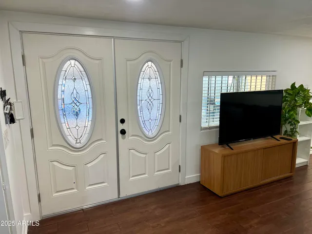 a living room with furniture a clock and a flat screen tv