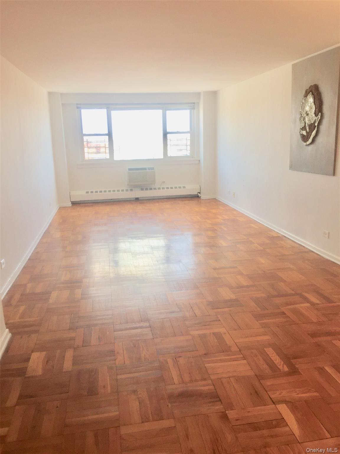 89-00 170th Street, Unit 6G Queens, NY 11432 - Photo 2 of 9 Unfurnished room with a baseboard heating unit and baseboards