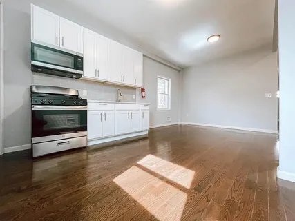 a kitchen with granite countertop a stove and a wooden floors