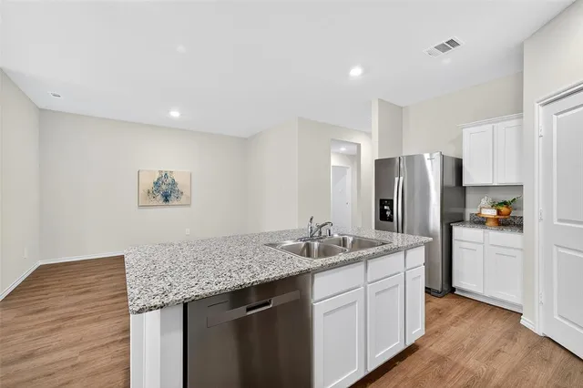 a kitchen with stainless steel appliances granite countertop a refrigerator and a sink