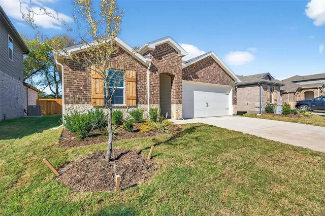 a view of a white house next to a yard with potted plants