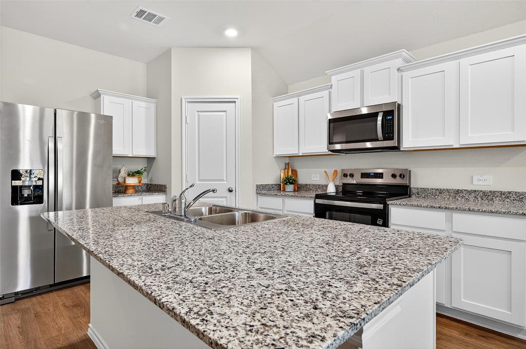 4208 Carnation Drive Sherman, TX 75090 - Photo 7 of 34 a kitchen with stainless steel appliances granite countertop a sink stove and refrigerator