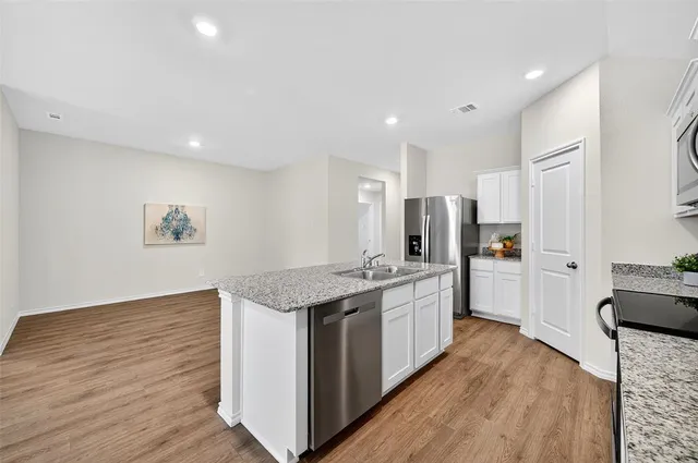 a kitchen with stainless steel appliances granite countertop a stove and a refrigerator