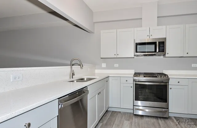 a kitchen with white cabinets and stainless steel appliances