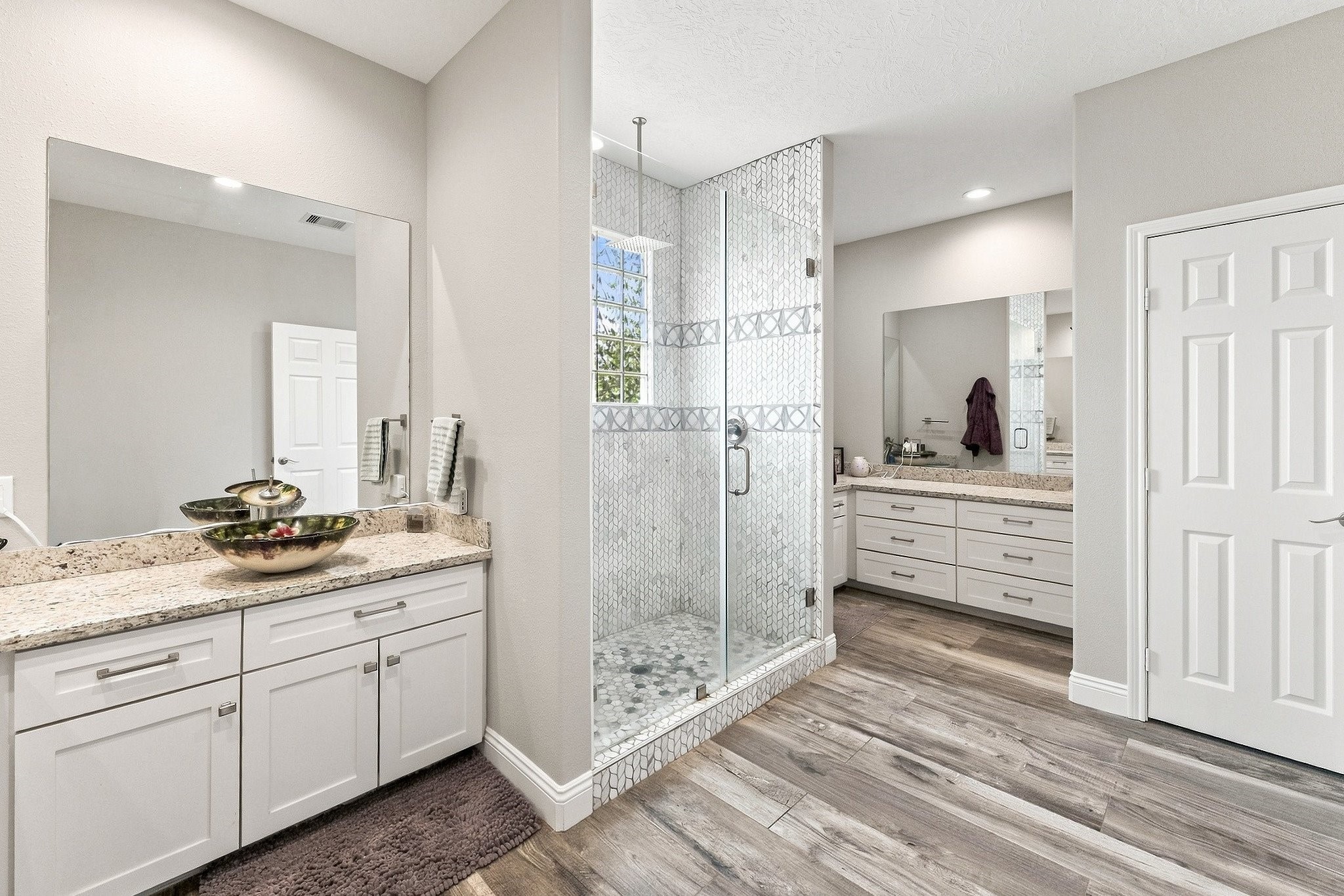 9010 Point Barrow Road Beach City, TX 77523 - Photo 21 of 50 Separate vanity areas create individual spaces within the primary bath, each with extensive cabinetry, countertop space & its own oversized mirror.