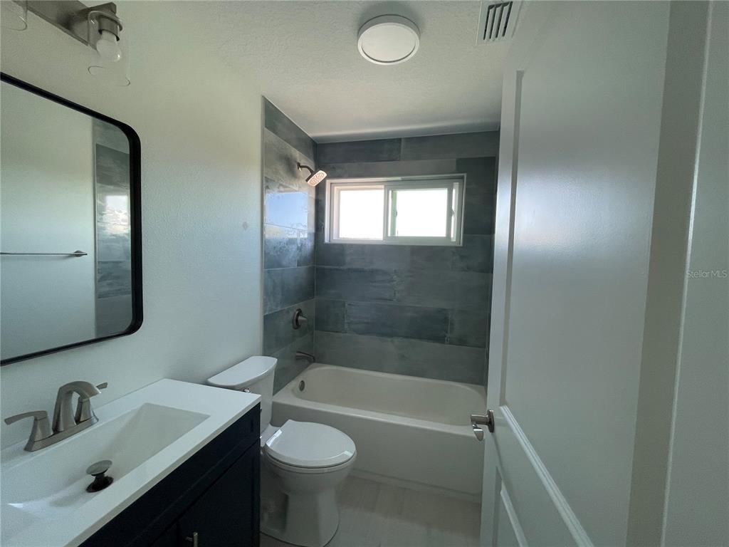 711 Gulf Boulevard Indian Rocks Beach, FL 33785 - Photo 16 of 19 a bathroom with a bathtub shower sink vanity and toilet