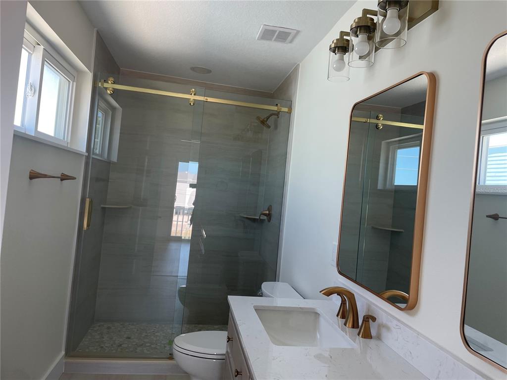 711 Gulf Boulevard Indian Rocks Beach, FL 33785 - Photo 17 of 19 a bathroom with a shower and a toilet