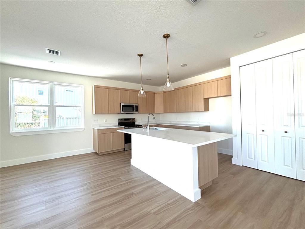 711 Gulf Boulevard Indian Rocks Beach, FL 33785 - Photo 4 of 19 a large kitchen with stainless steel appliances granite countertop a stove and wooden floor