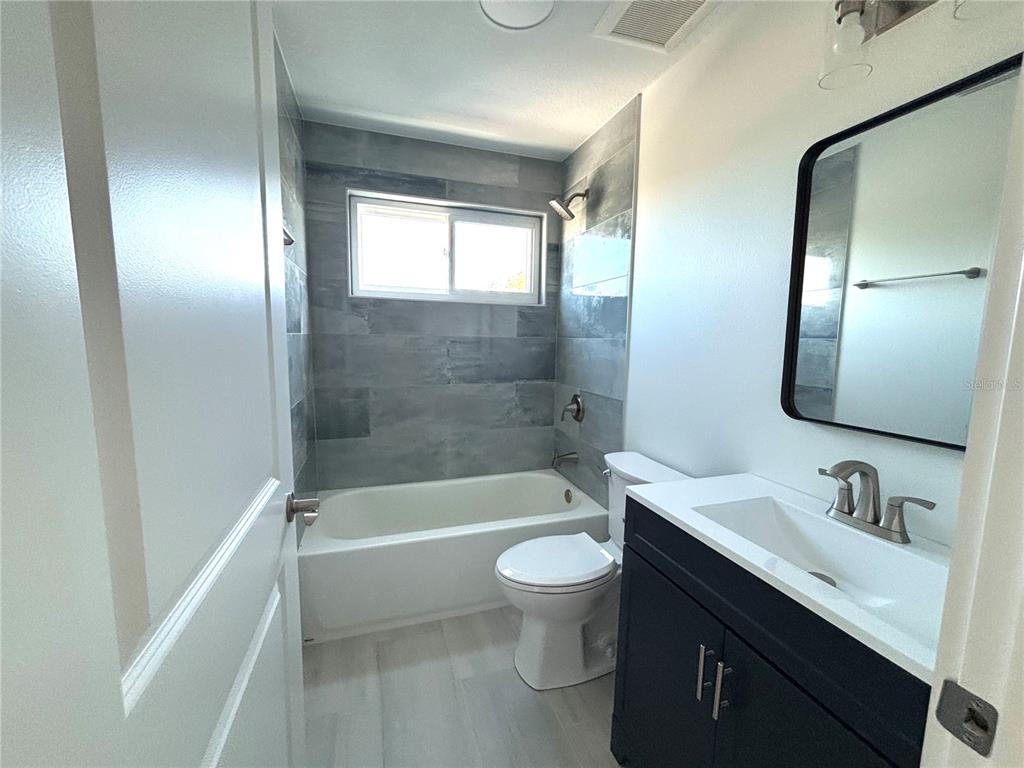 711 Gulf Boulevard Indian Rocks Beach, FL 33785 - Photo 5 of 19 a bathroom with a bathtub shower sink mirror vanity and toilet