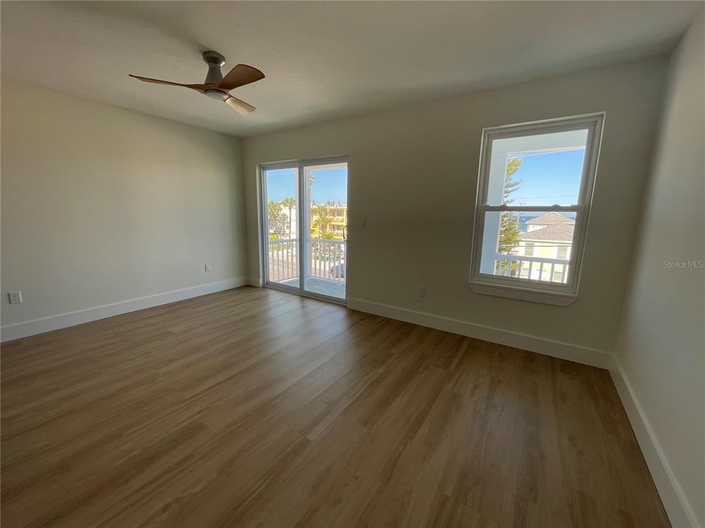 711 Gulf Boulevard Indian Rocks Beach, FL 33785 - Photo 10 of 19 a view of an empty room with a window and wooden floor