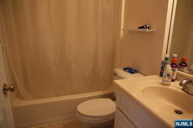 a bathroom with a sink a toilet and shower curtain