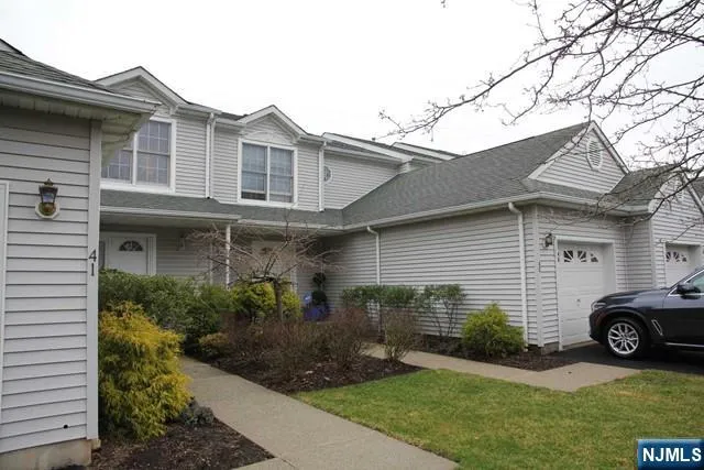 a front view of a house with a garden and plants