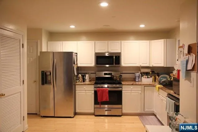 a kitchen with stainless steel appliances granite countertop a refrigerator stove and sink