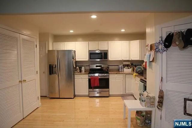 a kitchen with stainless steel appliances granite countertop a refrigerator and a stove top oven