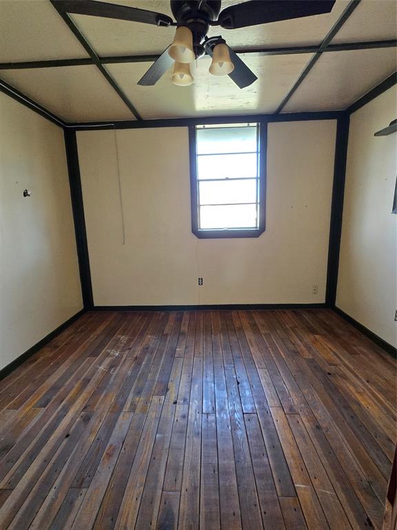 608 Ripley Street Coleman, TX 76834 - Photo 15 of 23 a view of an empty room with wooden floor and a ceiling fan