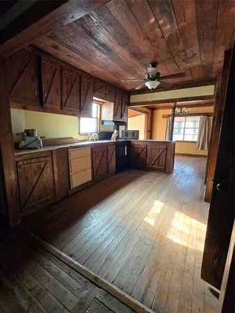 a view of a room with wooden floors and furniture