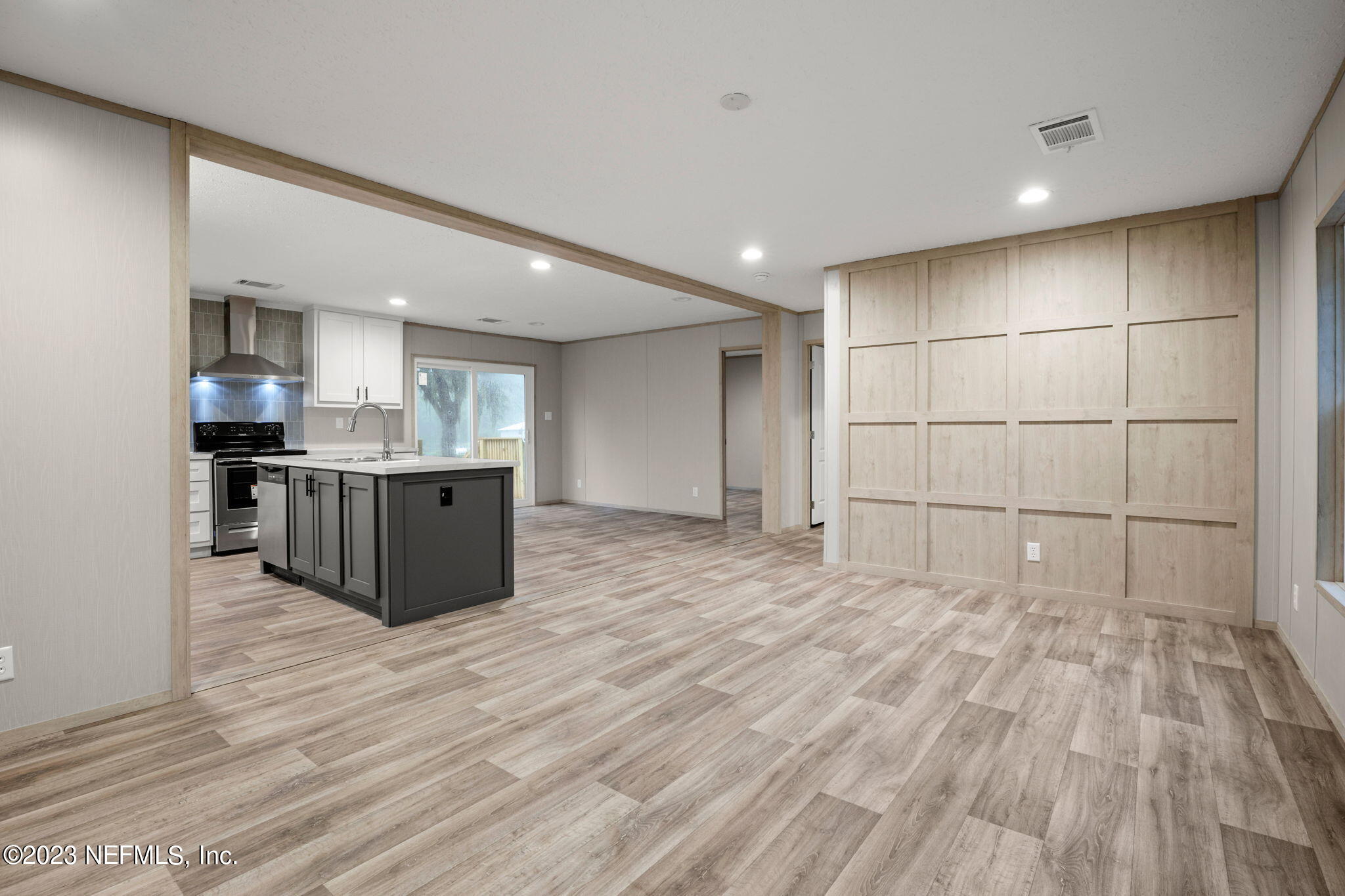 1100 Mulberry Landing Road Hilliard, FL 32046 - Photo 14 of 32 a large white kitchen with wooden floor and stainless steel appliances