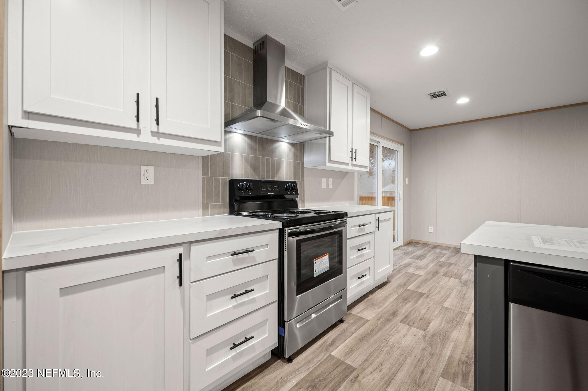 1100 Mulberry Landing Road Hilliard, FL 32046 - Photo 5 of 32 a kitchen with stainless steel appliances a stove refrigerator and cabinets