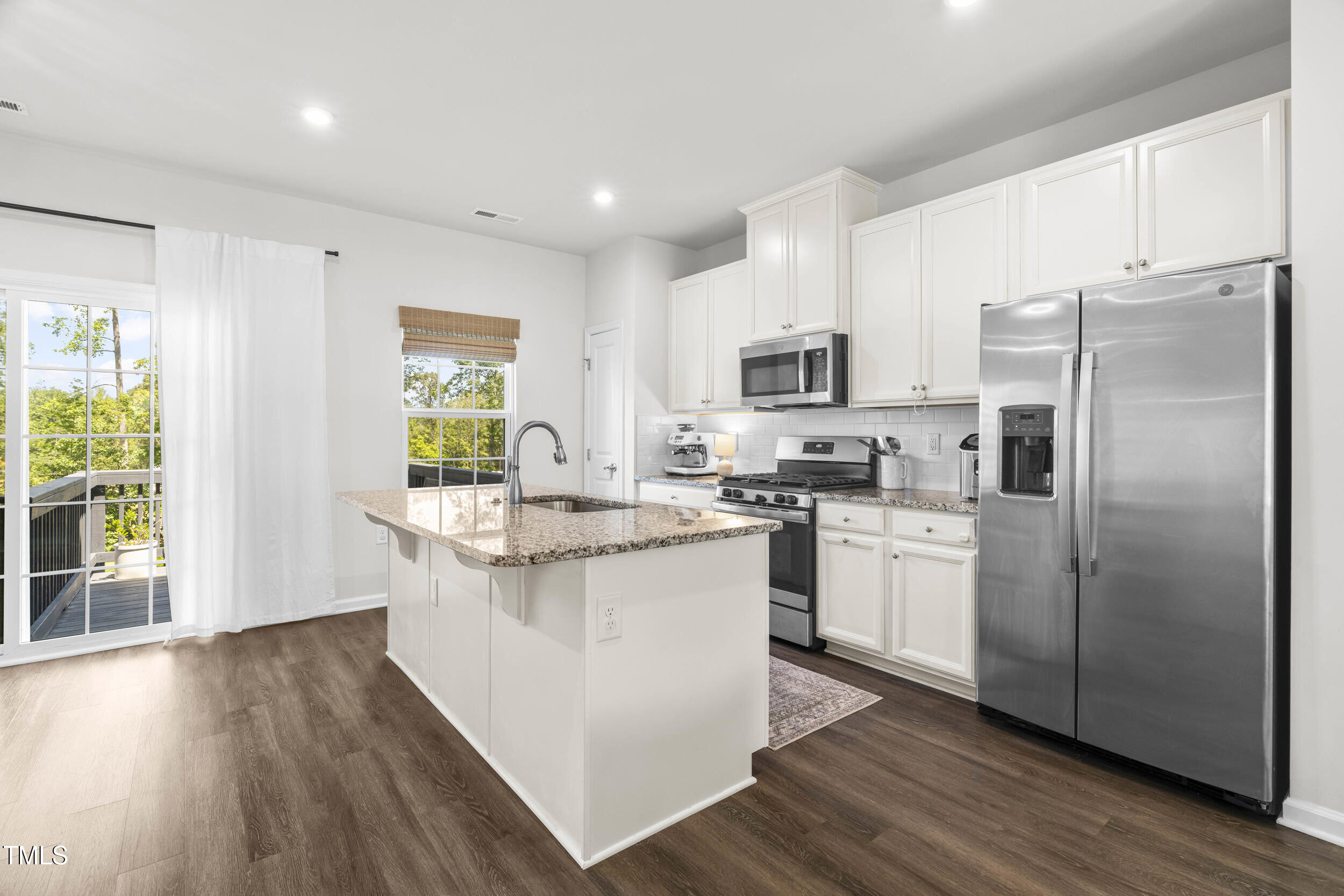 6607 Pathfinder Way Raleigh, NC 27616 - Photo 12 of 38 a kitchen with stainless steel appliances granite countertop a refrigerator a stove top oven a sink and dishwasher with wooden floor