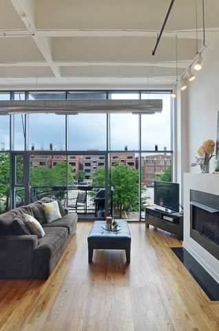 1224 West Van Buren Street, Unit 213 Chicago, IL 60607 - Photo 2 of 16 a living room with furniture and a floor to ceiling window