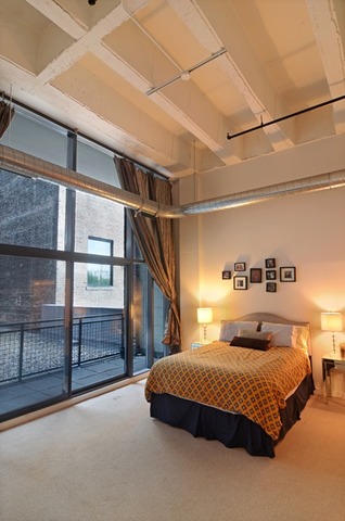 1224 West Van Buren Street, Unit 213 Chicago, IL 60607 - Photo 11 of 16 a bedroom with a large bed and a window