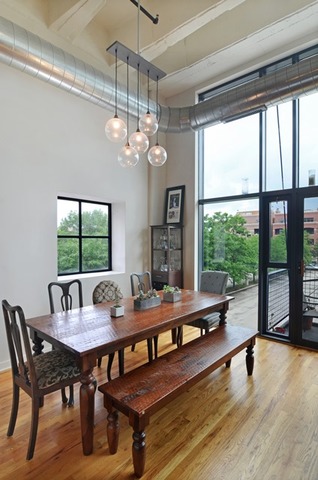 1224 West Van Buren Street, Unit 213 Chicago, IL 60607 - Photo 8 of 16 a dining room with wooden floor a chandelier a wooden table and chairs