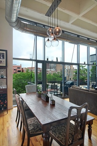1224 West Van Buren Street, Unit 213 Chicago, IL 60607 - Photo 9 of 16 a view of a dining room with furniture large windows and wooden floor