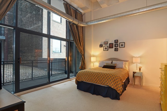 1224 West Van Buren Street, Unit 213 Chicago, IL 60607 - Photo 10 of 16 a bedroom with a bed and large window