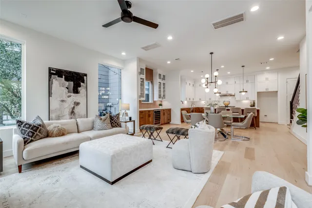 a living room with furniture kitchen view and a chandelier