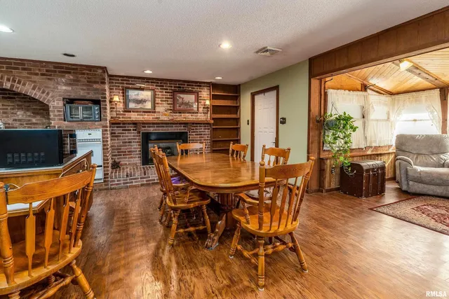 a dining hall with stainless steel appliances a dining table and chairs with wooden floor