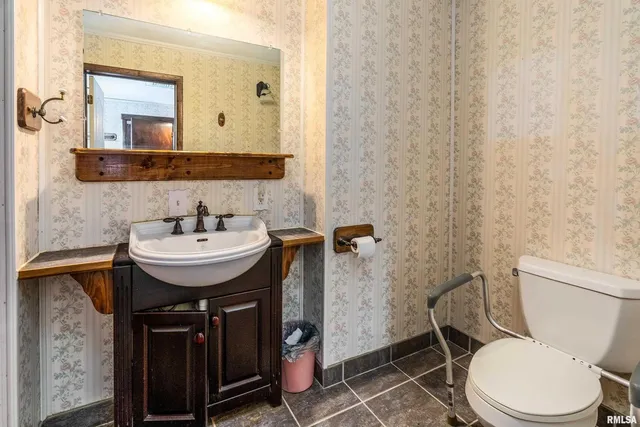 a bathroom with a sink a toilet and a mirror