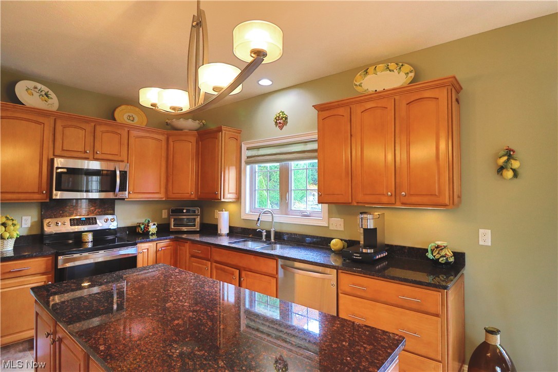 8257 Morley Road Mentor, OH 44060 - Photo 7 of 35 Kitchen with granite counters, sink, a chandelier, decorative light fixtures, and appliances with stainless steel finishes