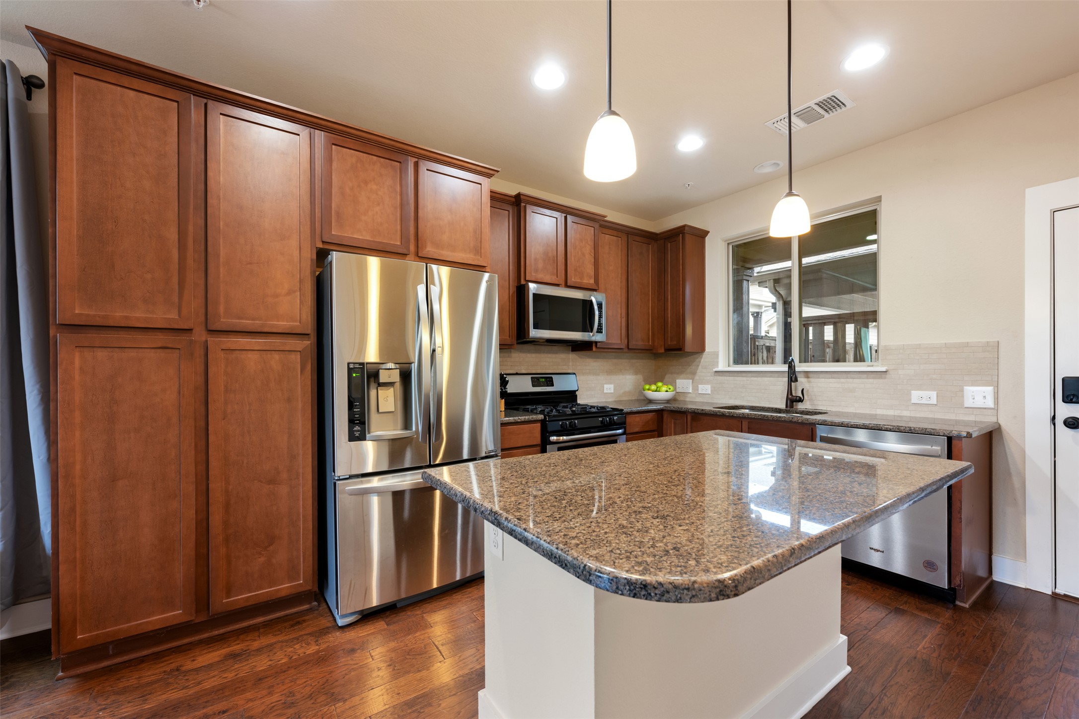 7615 Wolverine Street Austin, TX 78757 - Photo 11 of 40 a kitchen with granite countertop stainless steel appliances a refrigerator and a sink