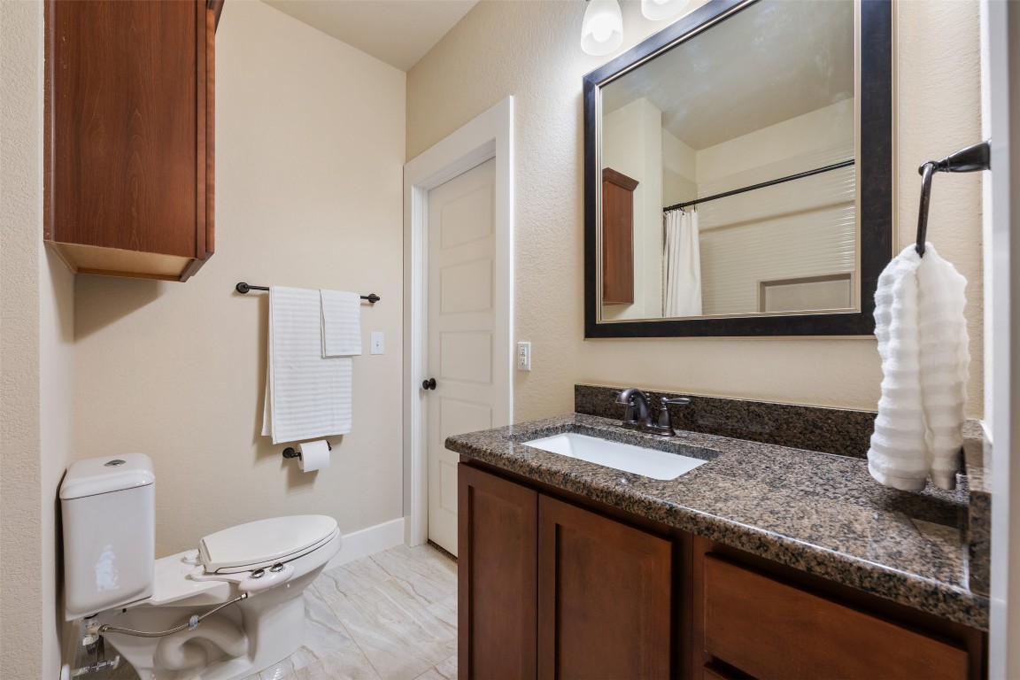 7615 Wolverine Street Austin, TX 78757 - Photo 21 of 40 a bathroom with a granite countertop sink and a mirror