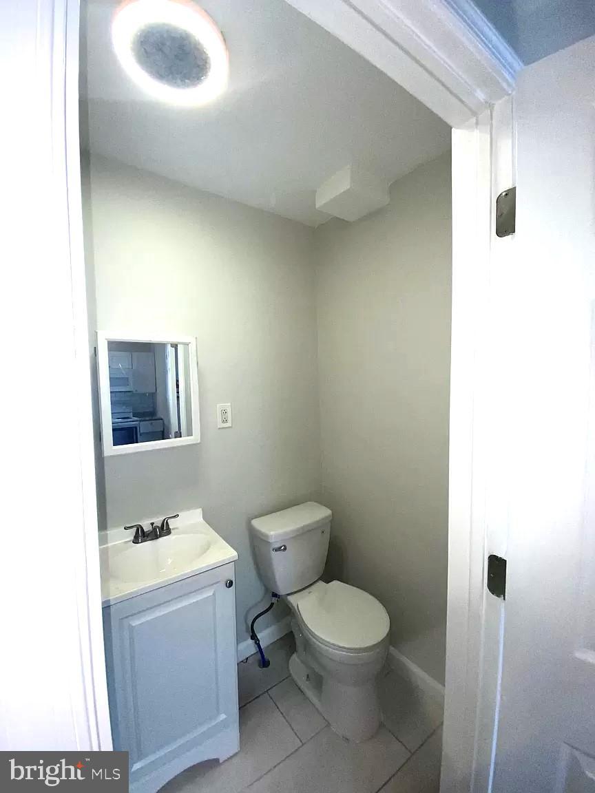 1464 North 52nd Street, Unit 2R Philadelphia, PA 19131 - Photo 4 of 4 a bathroom with a toilet sink and mirror