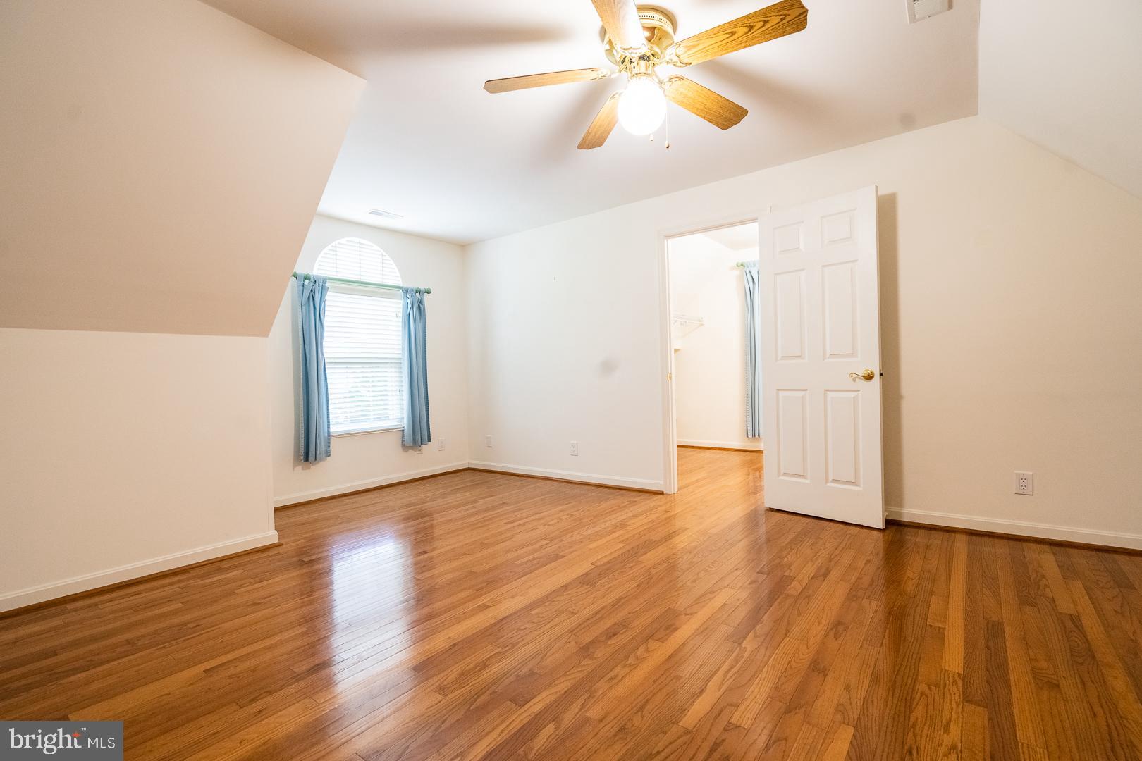5705 Solomons Island Road St. Leonard, MD 20685 - Photo 20 of 46 an empty room with wooden floor chandelier fan and windows