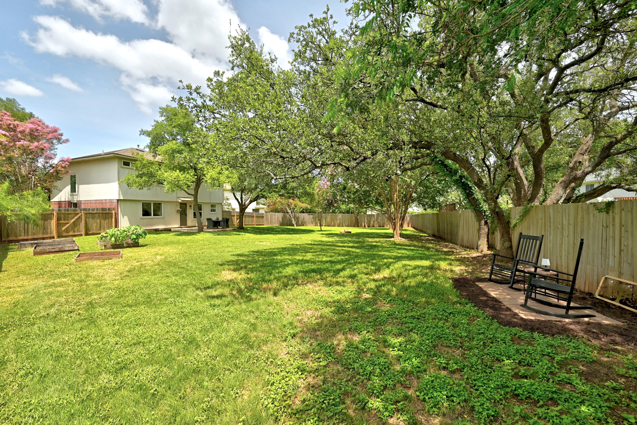 1801 Monks Tale Court Austin, TX 78748 - Photo 24 of 36 A generous, fenced backyard offers mature shade trees and verdant lawns, creating a private outdoor retreat.