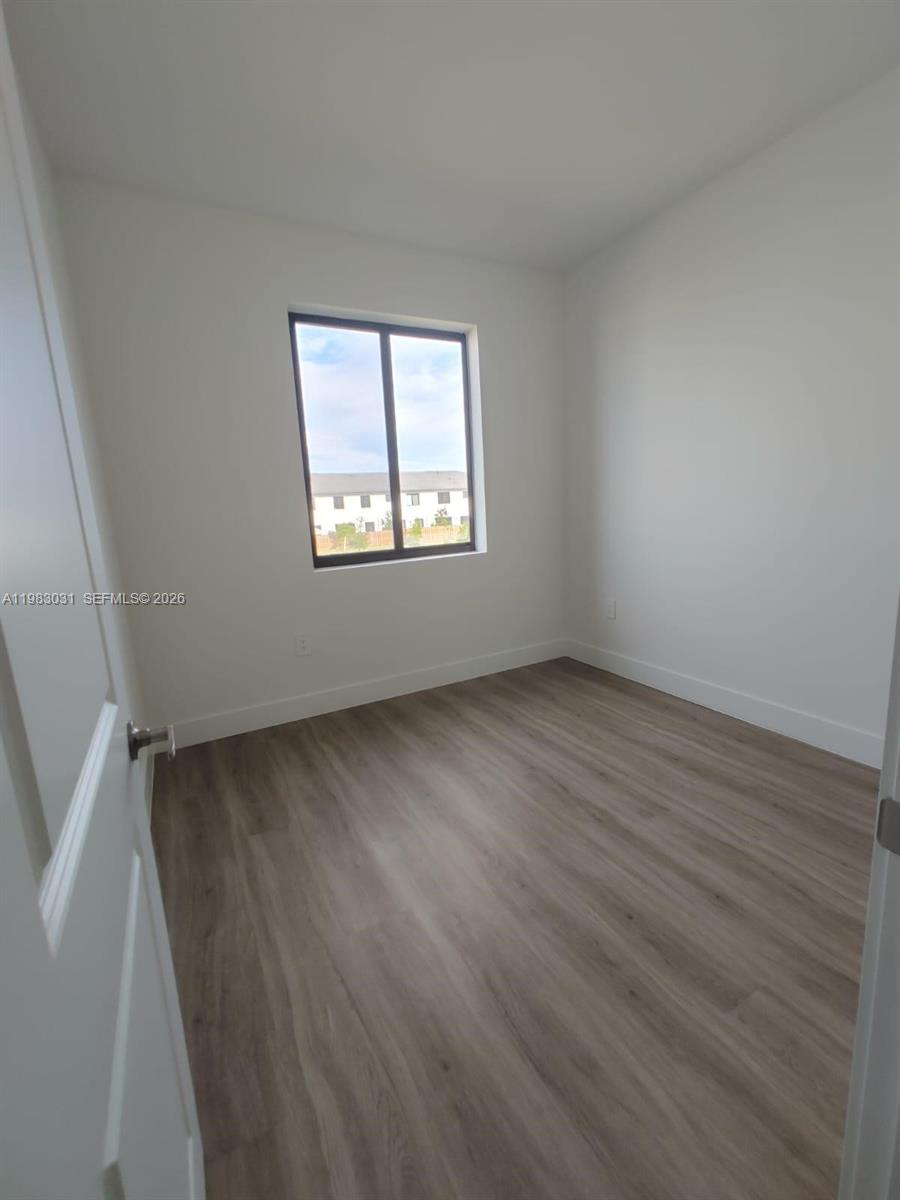 18983 Southwest 345th Terrace Homestead, FL 33034 - Photo 20 of 33 an empty room with wooden floor and windows