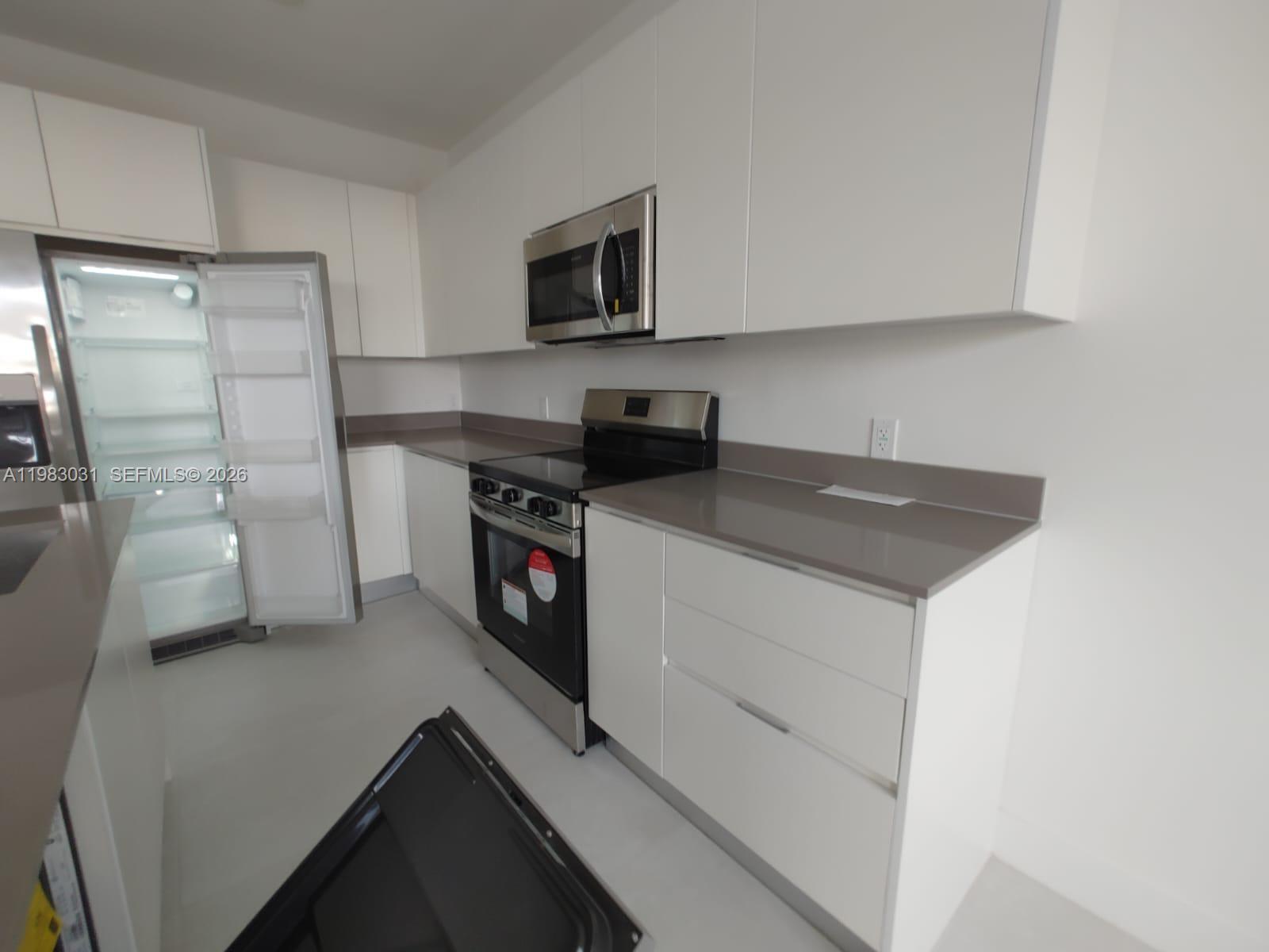 18983 Southwest 345th Terrace Homestead, FL 33034 - Photo 2 of 33 a kitchen with stainless steel appliances a refrigerator a sink a stove and microwave