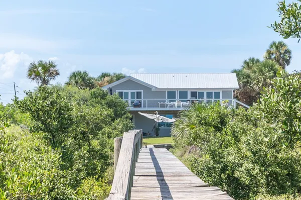 a front view of a house with a yard and potted plants